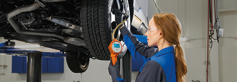 A Subaru technician checking tire pressure. | Hudson Subaru in Jersey City NJ