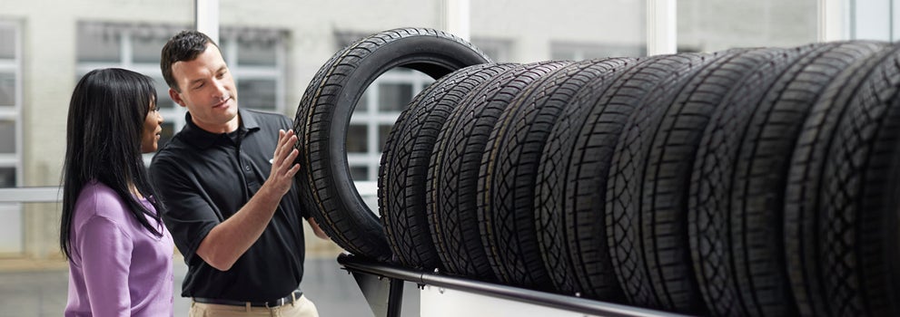 Subaru service representative showing customer a tire. | Hudson Subaru in Jersey City NJ